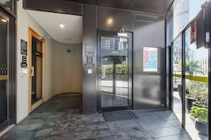A hotel entrance with a sauna and steam room, a glass door, and a sign indicating the maximum temperature for the sauna. - Skyline 40 Southbank Made Easy with Pool and Gym (Southbank)