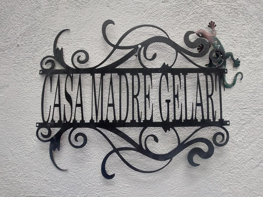 A decorative metal sign with the inscription 'CASA MAIDREGALE' mounted on a textured wall.