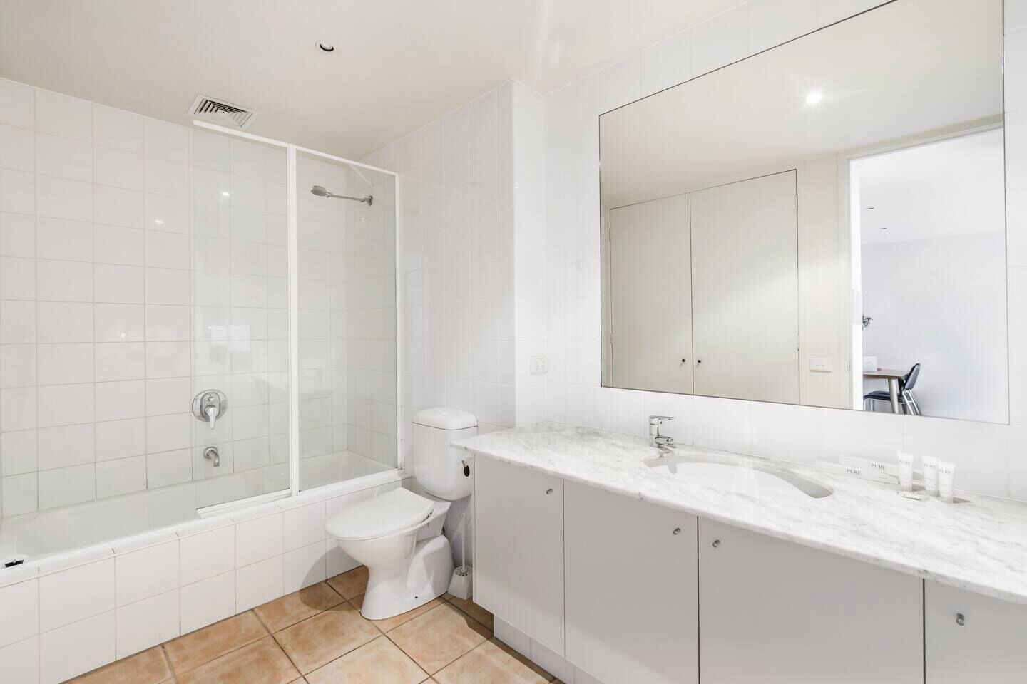 A modern bathroom with a shower, toilet, and vanity.