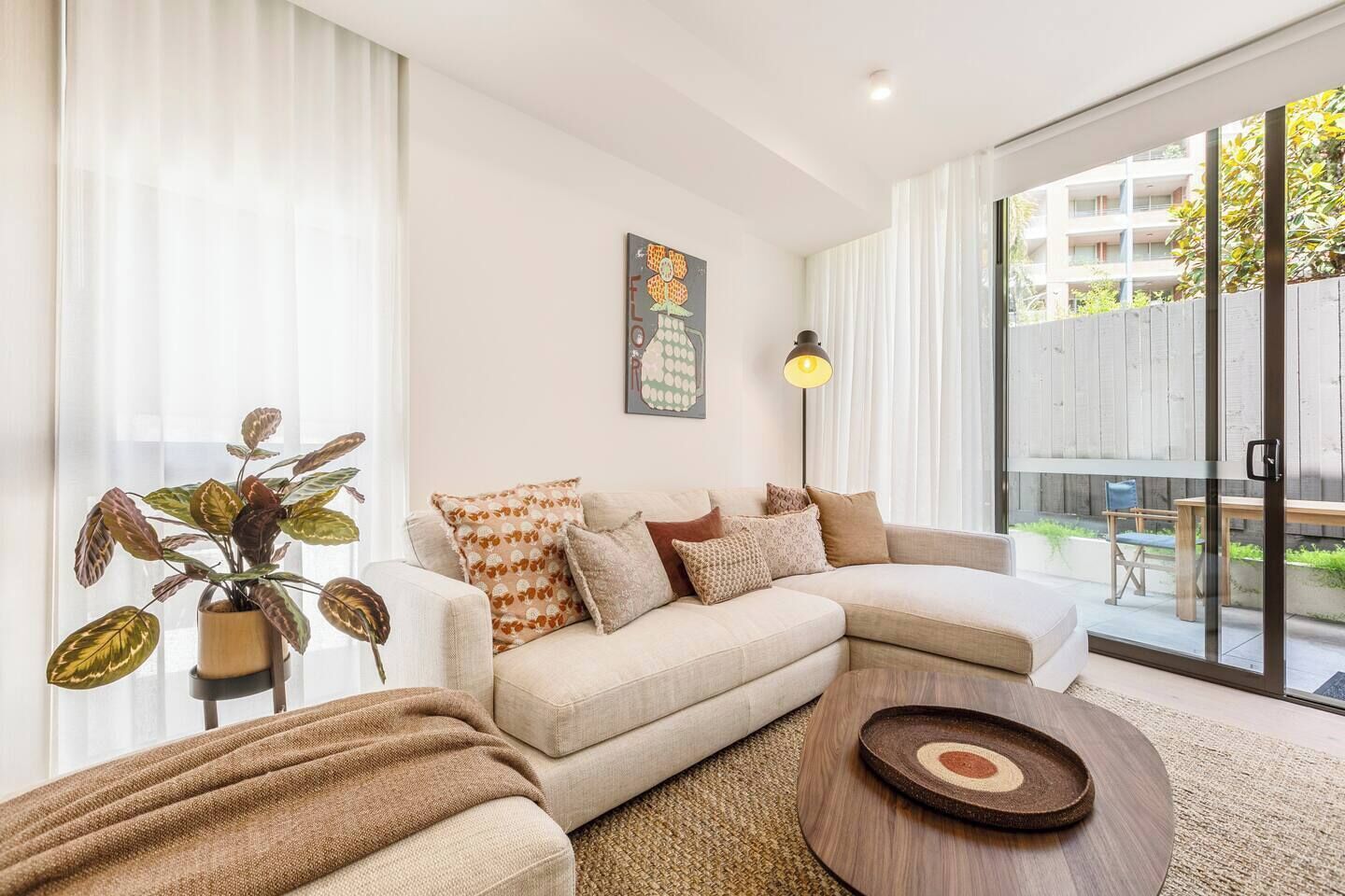 Un salon moderne avec un canapé, une table basse et une plante en pot.
