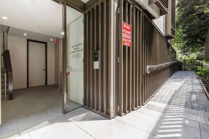 A modern building entrance with a fire indicator panel and a hydrant isolation valve sign. - Alexandra Elegance Riverside Living in Style (South Yarra)