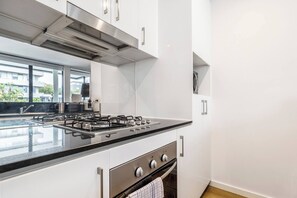 A modern kitchen with a gas stove, oven, and stainless steel cabinets. - Bay Street Terrace Spacious Indoor Outdoor Design (Port Melbourne)