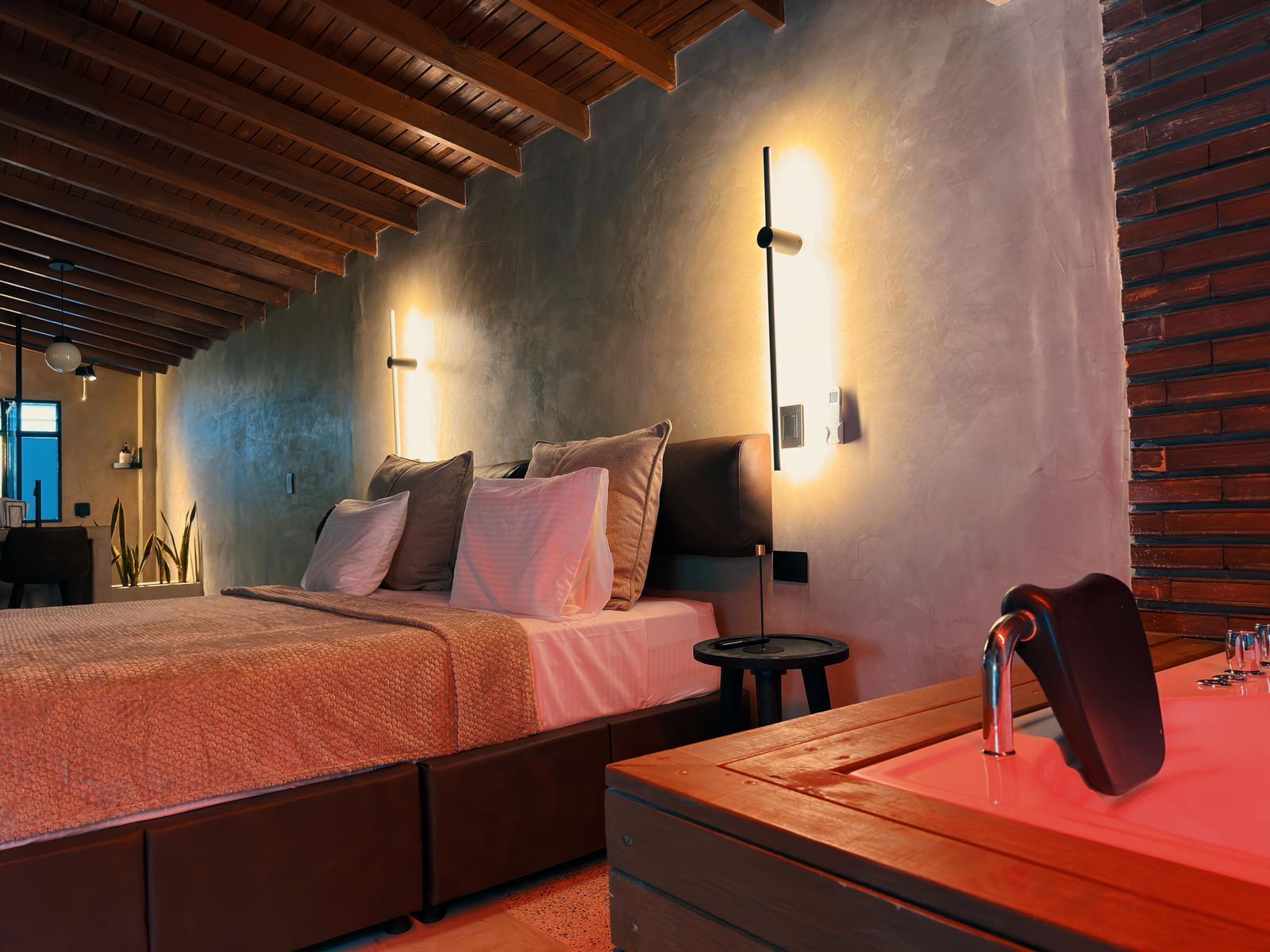 A bedroom with a bed, bedside tables, a nightstand, and a wooden headboard.