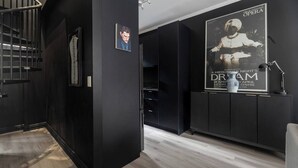 Un interior moderno con una escalera, un cartel del The Australian Opera y un jarrón decorativo.