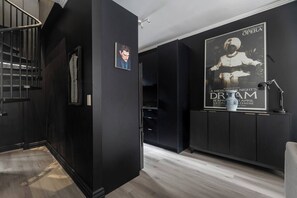 A modern interior with a staircase, a poster of The Australian Opera, and a decorative vase. - The New York Edit CBD Living with Private Rooftop (Melbourne)