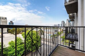 Ein Balkon mit Blick auf eine Stadtansicht, darunter Gebäude und eine Straße.