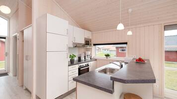 A modern kitchen with white cabinetry, a central island, and pendant lighting.