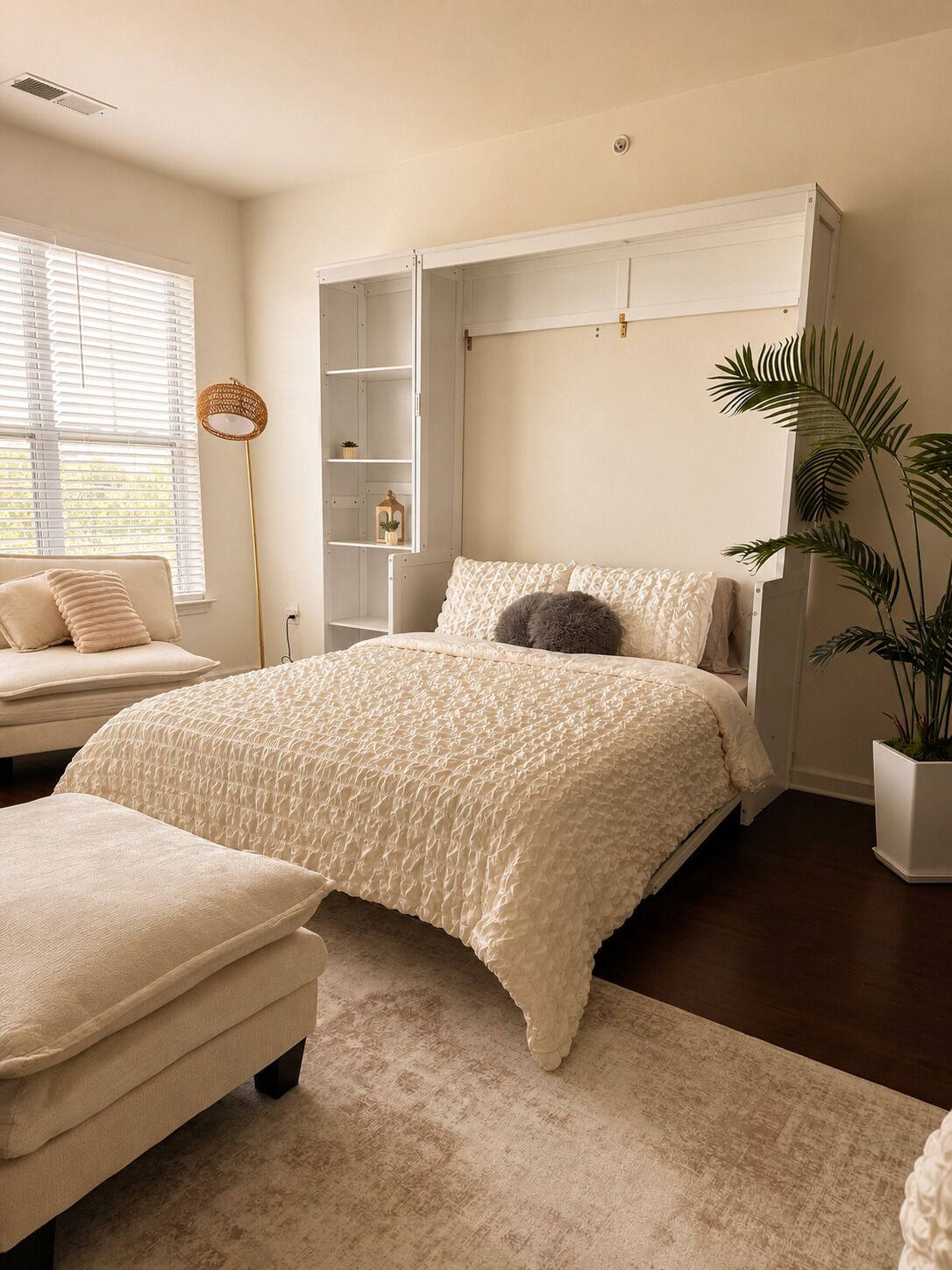 A bedroom with a bed, a nightstand, a bedside table, a wardrobe, and a potted plant.