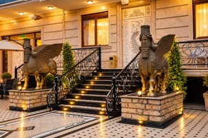 A grand staircase with ornate railings and golden statues of winged horses at the base.