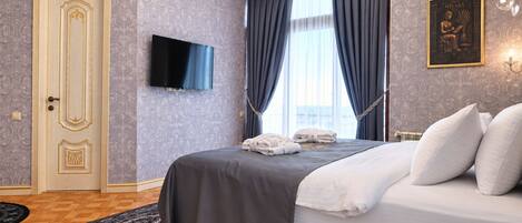 Une chambre d’hôtel comprenant un lit, un téléviseur à écran plat, une porte ornée de panneaux décoratifs et un tapis à motifs.