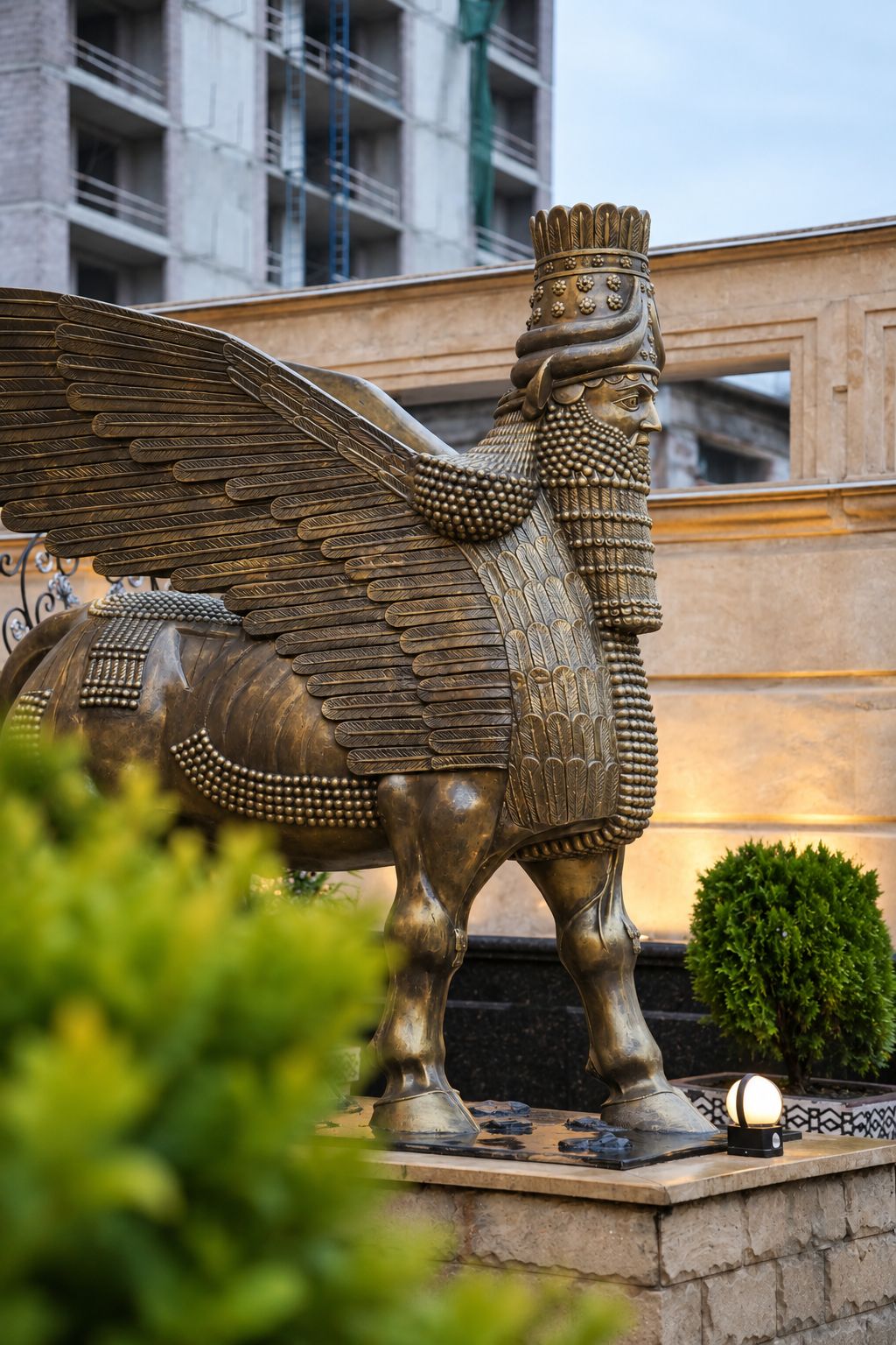 Eine bronzene Statue eines geflügelten Pferdes mit Reiter, auf einem Sockel in einer Stadt.