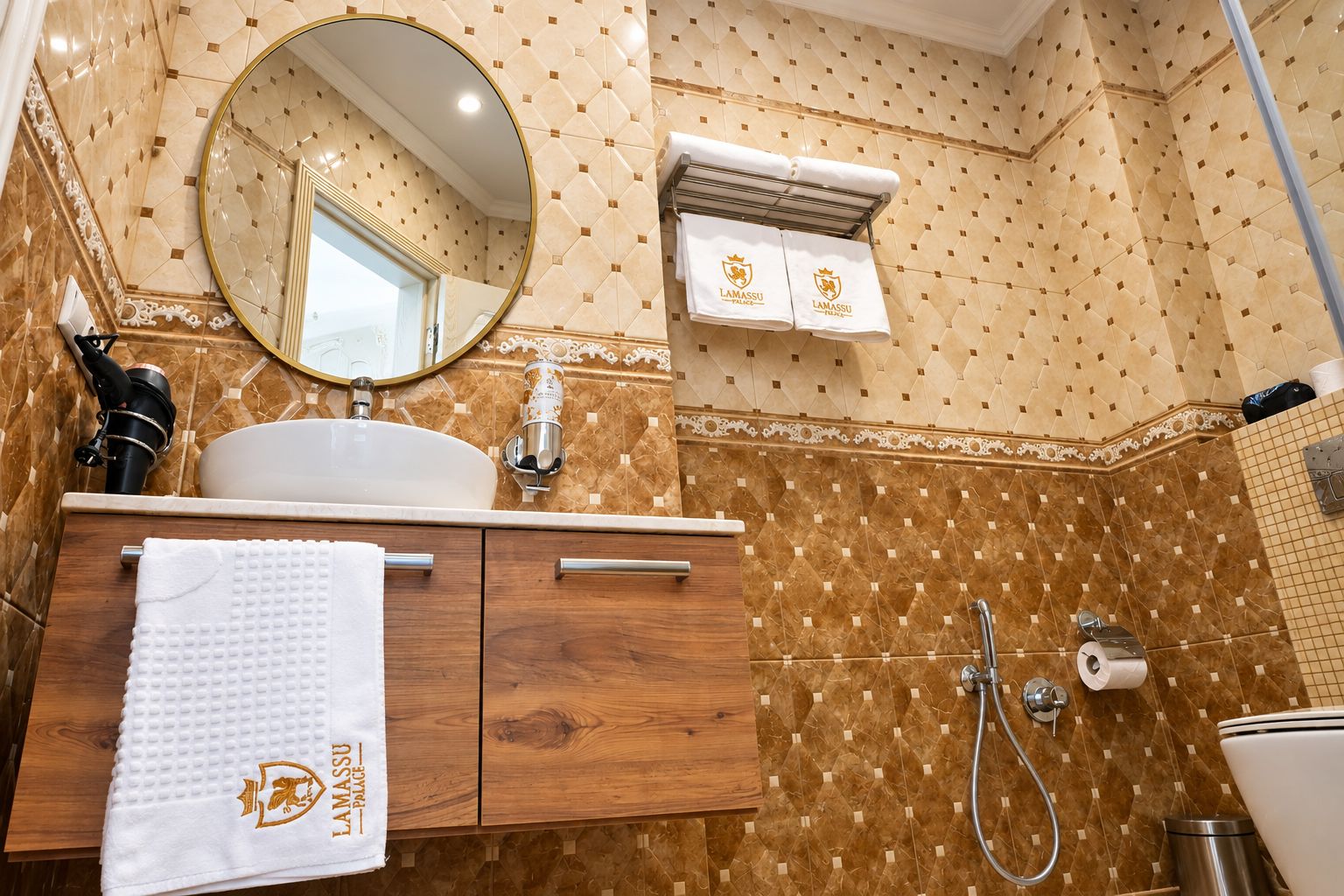 Un baño con un espejo redondo, un lavabo, un perchero con toallas y una ducha.