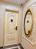 A room with a door marked '202' and a large mirror with a gold frame.