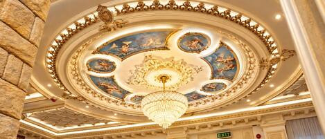 A grand ceiling with ornate gold detailing and a chandelier.