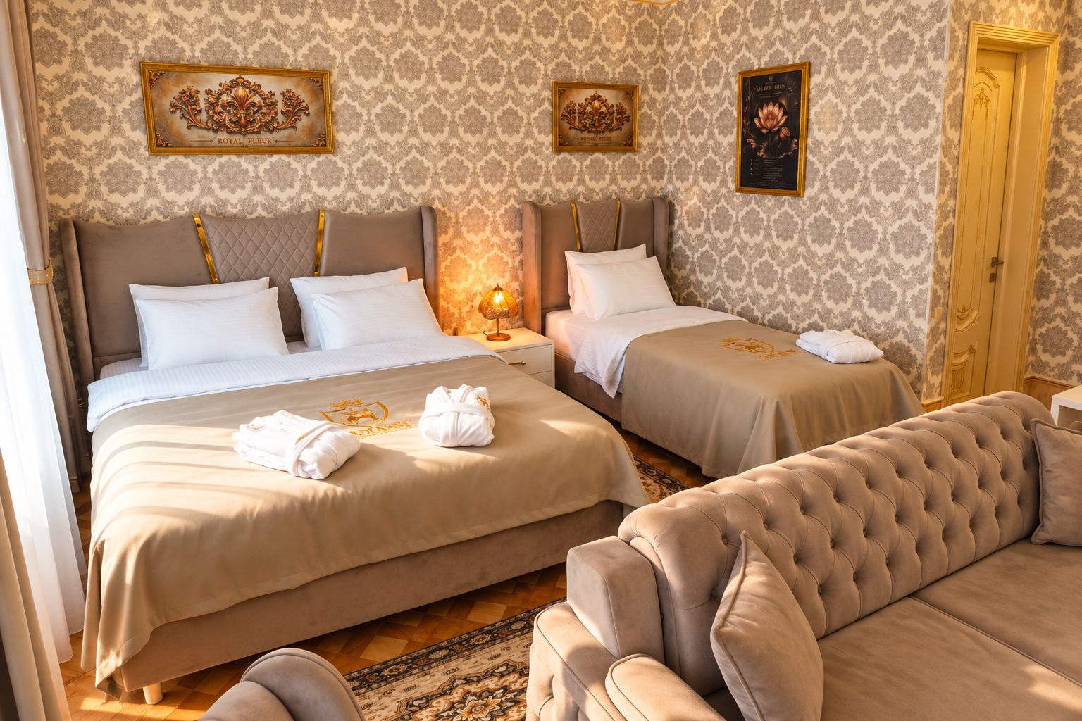A hotel room with two beds, a sofa, and a patterned wallpaper.