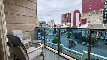 A balcony with a view of a cityscape, including buildings and a street.