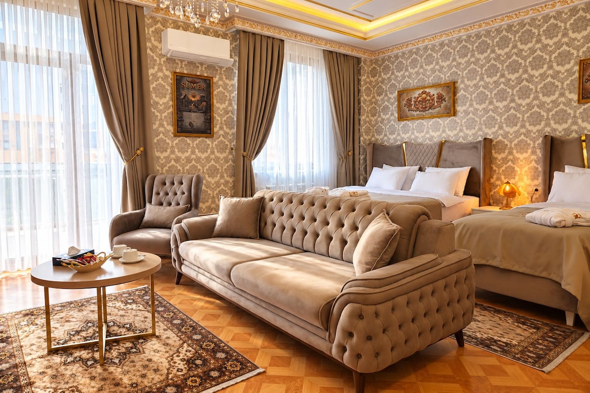 Una lujosa habitación de hotel con una cama grande, un sofá, una silla y una mesita.