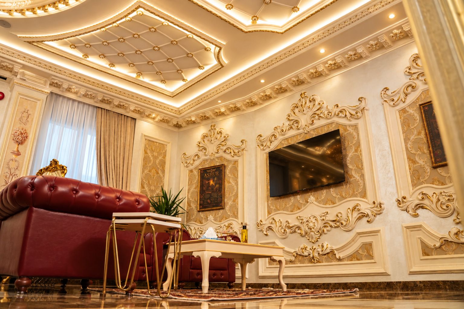 A luxurious room with a red sofa, a gold-framed television, ornate wall decorations, and a chandelier.
