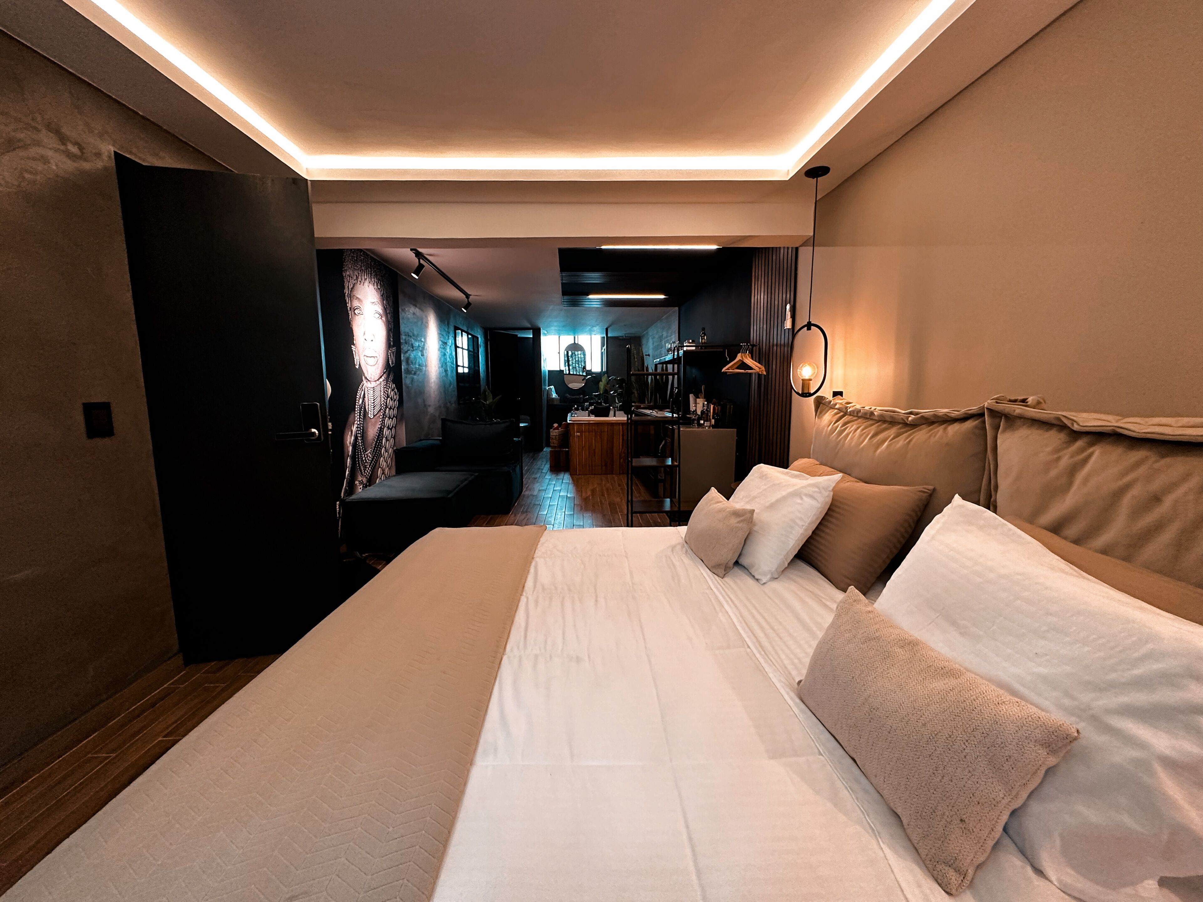 Ein modernes Hotelzimmer mit einem großen Bett, einem Schreibtisch und Blick in die Empfangshalle.