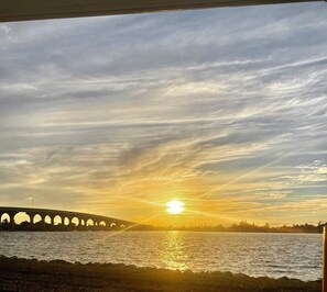A sunset over a body of water with a bridge in the background. - Perfect Vaction Retreat with Stunning Sunsets (St. Petersburg)