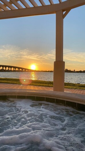 Ein Wasserspiel mit einer Brücke im Hintergrund bei Sonnenuntergang.
