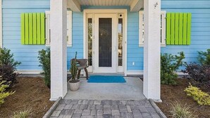 Een huis met een veranda, een deur en een kleine bank.
