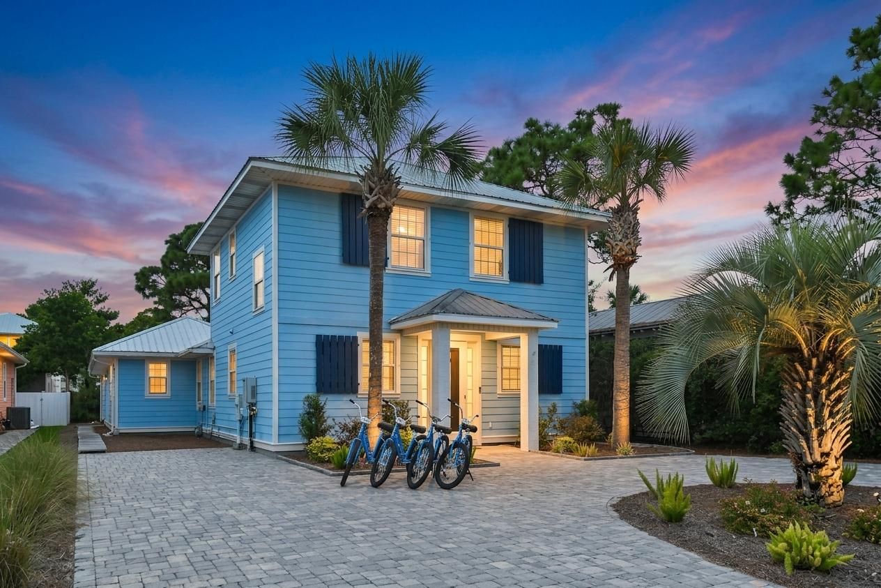 A two-story house with a blue exterior, a front porch, and a garage.