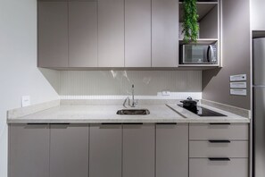 A modern kitchen with a stainless steel refrigerator, a microwave, and a sink. - Caraibas by Bhomy (São Paulo)