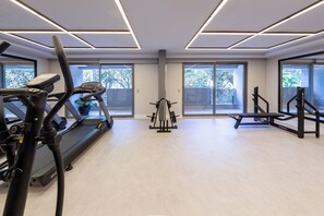 A modern gym with exercise equipment, large windows, and a clean, light-colored floor. - Caraibas by Bhomy (São Paulo)