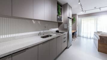 A modern kitchen with a built-in sink, cabinets, and a dining area with a table and chairs.