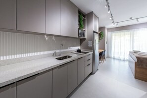 Una cocina moderna con un lavaplatos integrado, armarios y un comedor con mesa y sillas.