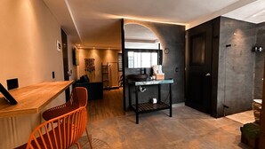 A modern kitchen with a wooden countertop, a sink, and a black cabinet. - Luxury Sense II (Medellín)