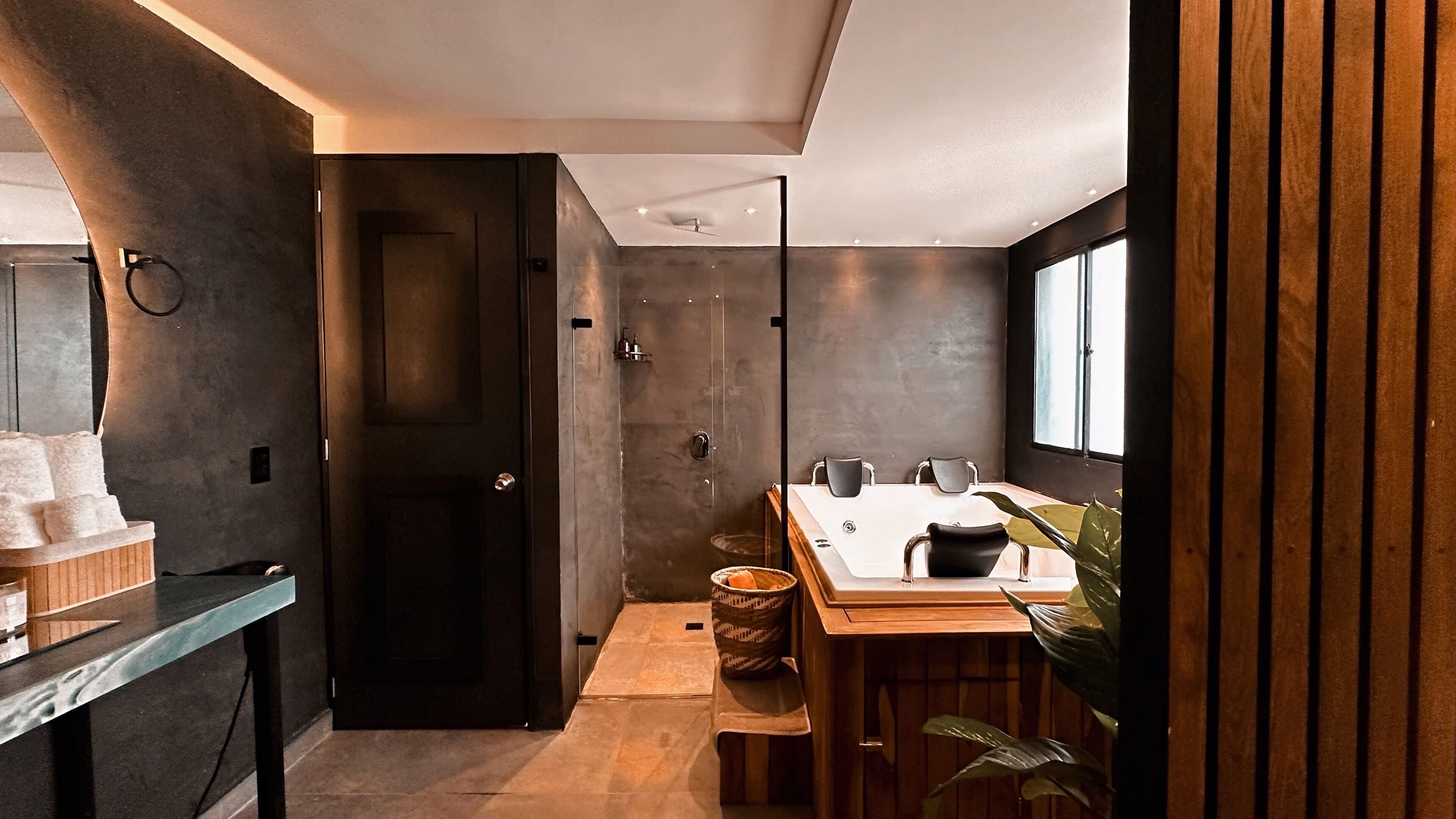 A modern bathroom with a shower, a sink with a mirror, and a wooden vanity.