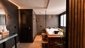 A modern bathroom with a shower, a sink with a mirror, and a wooden vanity. - Luxury Sense II (Medellín)