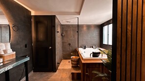 Ein modernes Badezimmer mit Dusche, Waschbecken mit Spiegel und einem Holzlagerplatz.