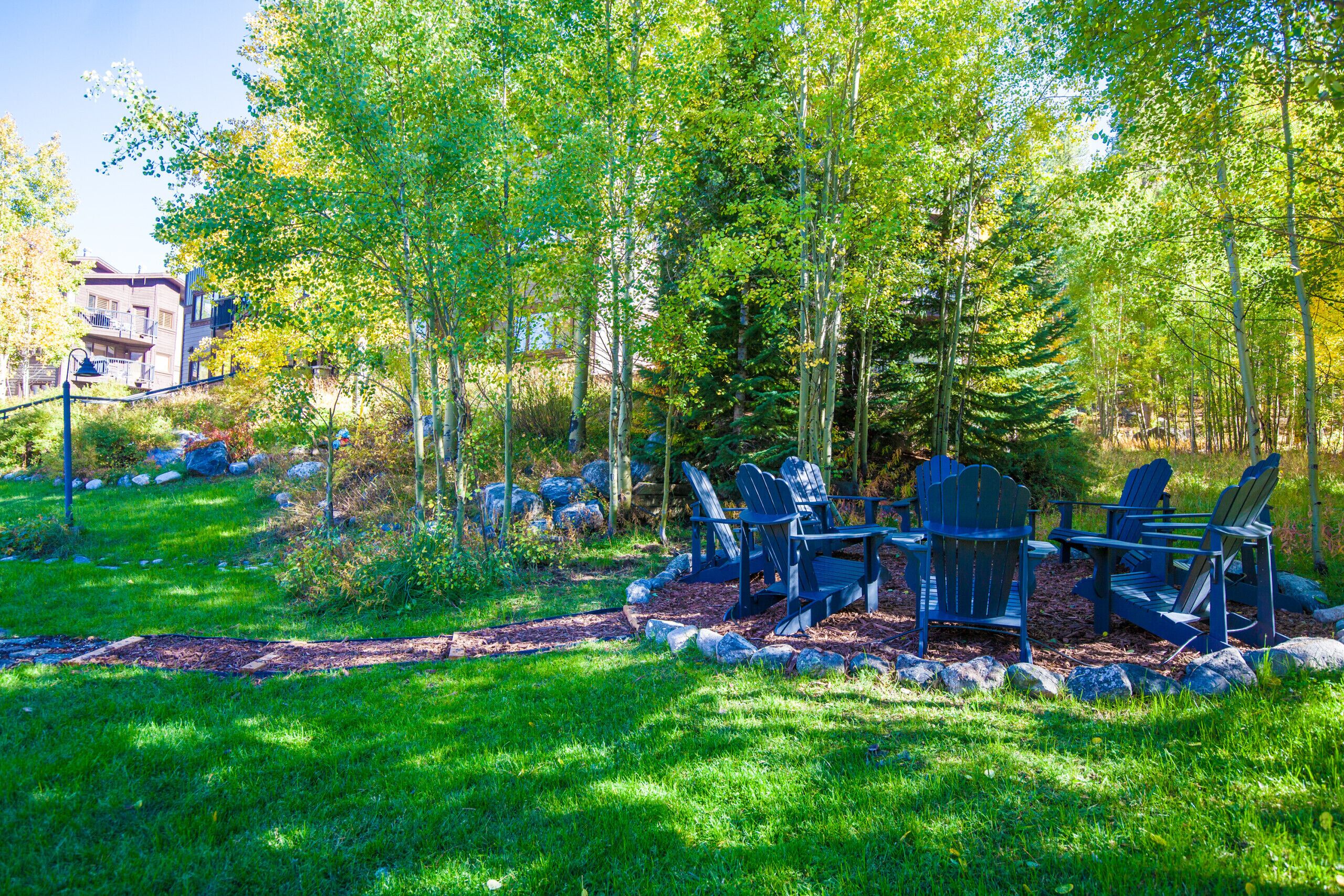A garden area with Adirondack chairs and a stone pathway.