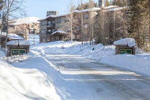 A snow-covered road leading to a building with a sign that reads "Woods Manor." - Walk to Lifts & Main St | Hot Tub (Breckenridge)