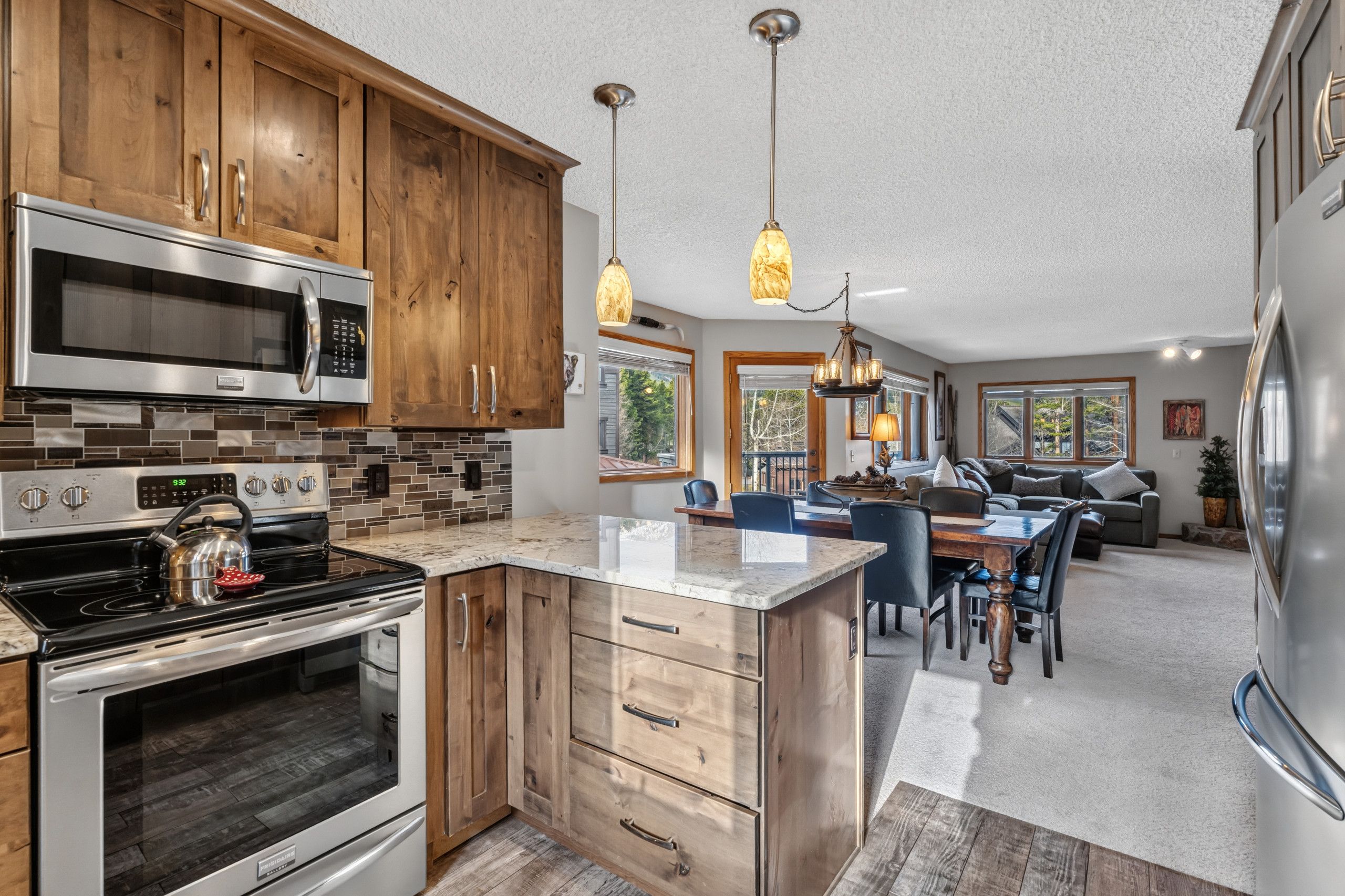 A modern kitchen with wooden cabinets, stainless steel appliances, and a central island.