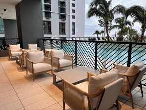 Eine Dachterrasse mit Sitzgelegenheiten im Freien und Blick aufs Meer.