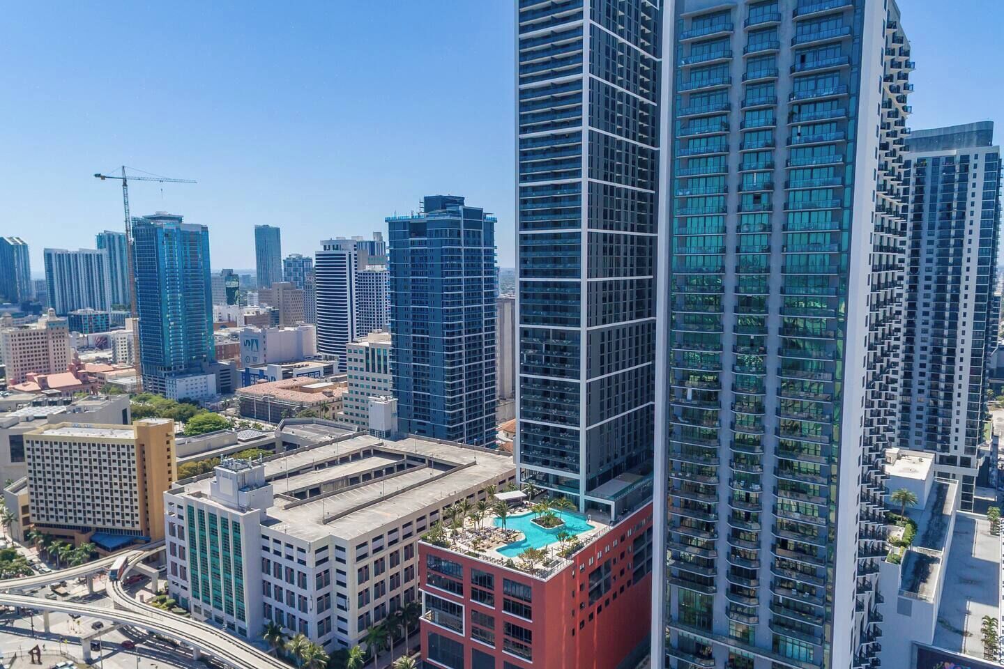 A high-rise building with a rooftop pool and a modern architectural design.