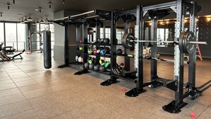 A gym with weightlifting equipment, a punching bag, and various exercise balls. - Modern Studio with Balcony in Downtown Miami (Miami)