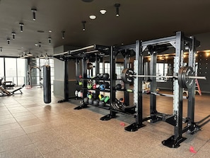 Ein Fitnessraum mit Gewichten, einem Sandsack und verschiedenen Trainingsbällen.