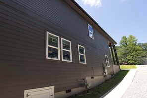 A two-story building with a brown siding exterior, three windows, and a small attached garage. - 8 Min to Duke + Downtown | Back Deck (Durham)