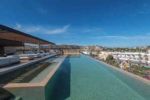 A rooftop infinity pool with clear water, lounge seating, and a view of the cityscape. - Rooftop Infinity Pool & Ocean Views (San José del Cabo)