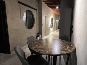 A conference room with a round table and chairs, a large circular window, and a long corridor with a wooden ceiling. - Luxury loft urban (Medellín)