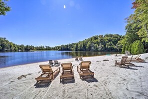 Ein Strand mit Liegestühlen und einem See.