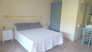 Ein Schlafzimmer mit Bett, Nachttisch, Kleiderschrank und Stuhl.