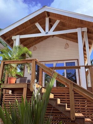 A wooden staircase leading to a building with a white facade and a sloped roof. - Conch Casitas - King or 2 Singles, AC, Shared Pool (Roatán)