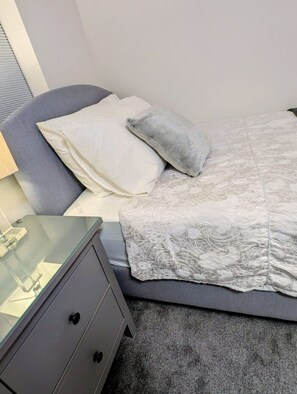 A bedroom with a bed, a nightstand, and a lamp. - Cambridge Town House (Cambridge)