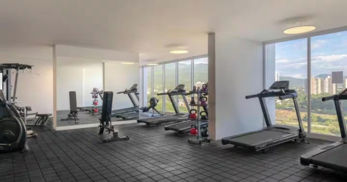 A gym with treadmills, weight machines, and kettlebells.